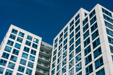 Fototapeta premium Modern apartment buildings reach for the blue sky in an urban setting during a sunny day