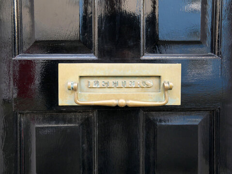 Brass Letterbox and Knocker with &ldquo;Letters&rdquo; on a Black Painted Wooden Front Door, Traditional British Home Detail