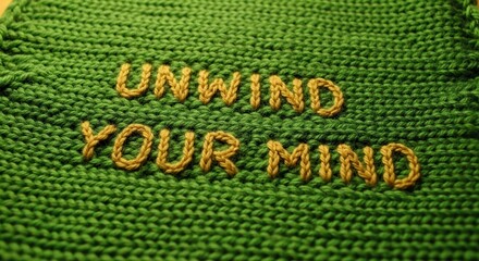 Embroidered green textile art urging you to unwind your mind for stress relief and peaceful thoughts, perfect for mental health and wellness promotions