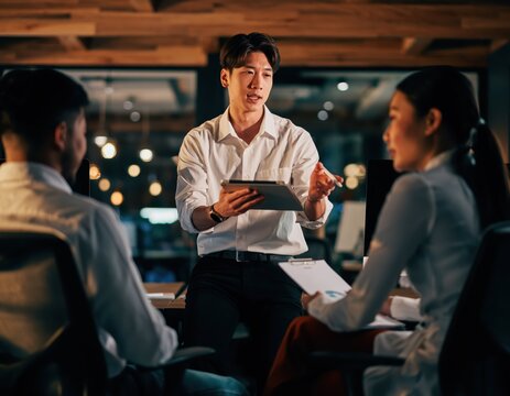 Young Man Presenting Detailed Technical Specification to Team Members