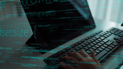 A close-up view of a hand typing on a keyboard with glowing code displayed on the screen, symbolizing modern programming and technology in a sleek workspace. Xenic