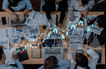 A diverse group of business professionals engaged in data analysis with laptops and reports, featuring data visualization elements, reflecting teamwork and strategy in a modern workspace. Scalp