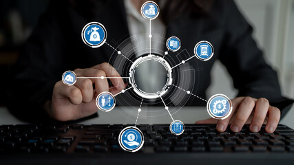 A business professional manipulates a keyboard while engaging with digital financial icons, representing innovative technology in modern finance and investment strategies. Crux