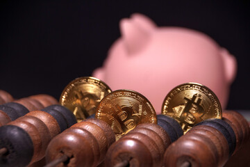 Three gold coins with the letter B on them are on a wooden board