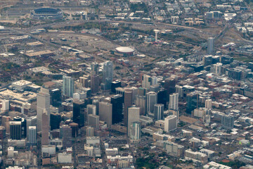 Aerial view of Denver, Colorado showcases the downtown area with prominent skyscrapers. Ball Arena is visible as a distinct round structure, as well as Empower Field at Mile High Stadium