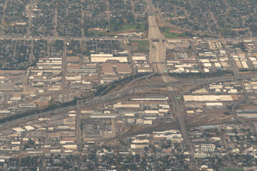 Aerial view of the intersection of Interstate 70 and Interstate 25 in Denver, Colorado. The image shows a complex network of highways intersecting amidst a densely built urban landscape.
