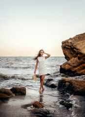 A person standing in front of a rock next to a body of water