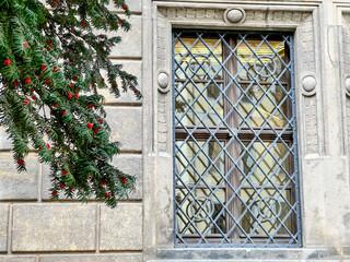 Yew branch with red berries adorning old stone building window
