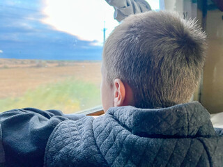 Child looking out train window during journey