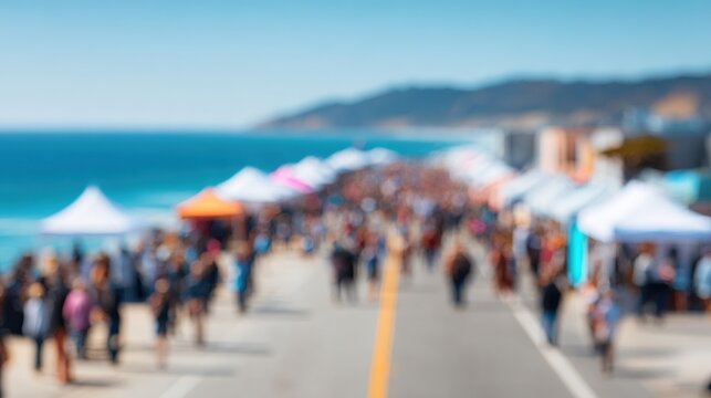 Blurred coastal street market with people and tents under a bright blue sky