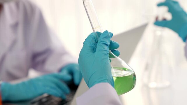 Laboratory researcher develop new medicine or cure use colorful chemical liquid in lab tube. Technological advance of healthcare with scientific or chemistry expertise and laboratory equipment. Rigid.