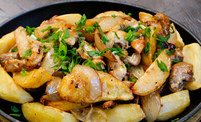 Oven baked potatoes with mushrooms and rosemary on rustic white wooden table, selective focus. High quality photo