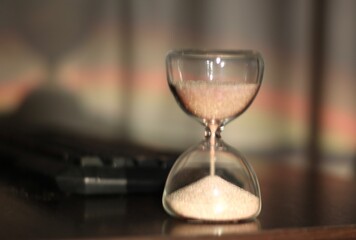 hourglass with the sand and computer keyboard time and work