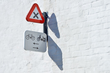 Road signs on white brick wall