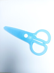Blue scissors on a white background, special scissors for children can only be used to cut paper