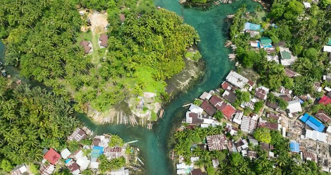 Blue clear water over the Bogac Cold Spring surrounded by villlages and tropical forest. Surigao del Sur, Philippines.