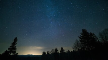 Time-lapse of stars moving across the night sky with glowing fireflies in foreground, creating a magical, ethereal scene of cosmic motion, celestial beauty, and tranquil nighttime atmosphere