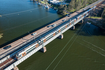 Aerial view of a New South Wales D set "Mariyung" intercity train crossing Dora Creek in the Lake Macquarie region, NSW, Australia.