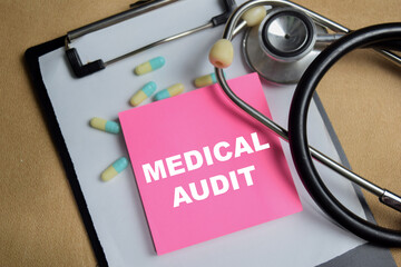 Concept of medical audit write on sticky notes isolated on Wooden Table.