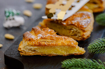 Two pieces of galettes with a crown and a spruce branch on the table.