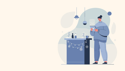 Woman in cozy winter clothing uses a digital tablet next to holiday decor Leisure and technology