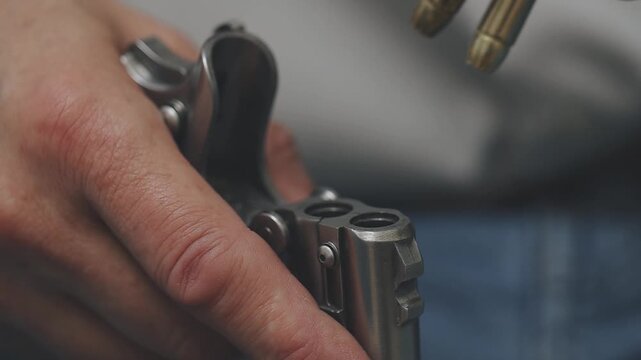 Loaging handgun with new ammunition in home location by older man