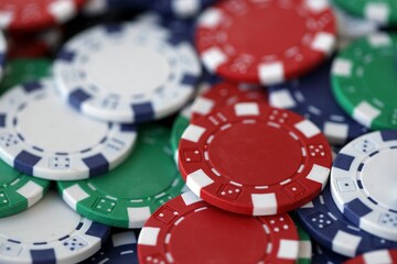 Close up of a group of casino chips on a green mat for poker or dice games indoors