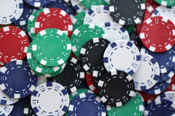 Close up of a group of casino chips on a green mat for poker or dice games indoors