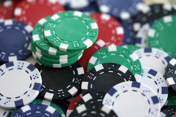 Close up of a group of casino chips on a green mat for poker or dice games indoors