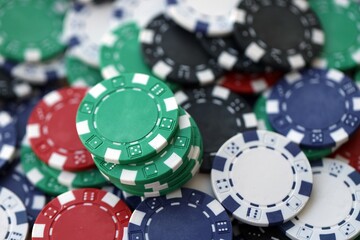 Close up of a group of casino chips on a green mat for poker or dice games indoors