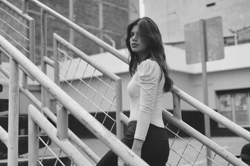 Young woman posing on urban stairs for modern fashion.World Fashion Day