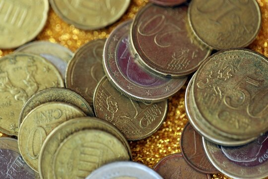 Big amount of euro coins on golden glitter background