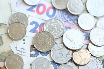 Ukraine money coins lying on mixed hryvnia banknotes. Finance background concept.