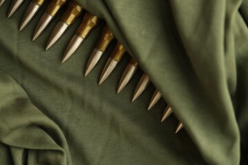 Many rifle bullets on military camo green fabric background