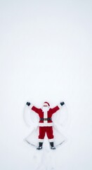 Obraz premium Santa Claus making a snow angel in pristine white snow. Christmas holiday fun and festive winter concept for seasonal greeting card design.