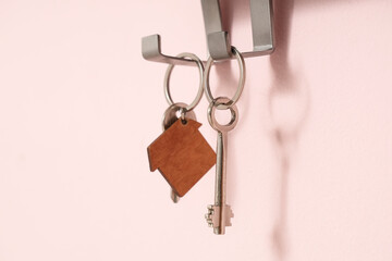 Rack with key from house on pink wall, closeup