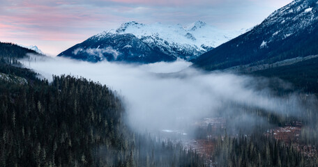 Snowy Mountain Valley Beneath Misty Forest Fog in BC, Canada at Dusk