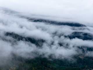 Misty Mountain Ranges Shrouded in Clouds Above BC Forests, Canada