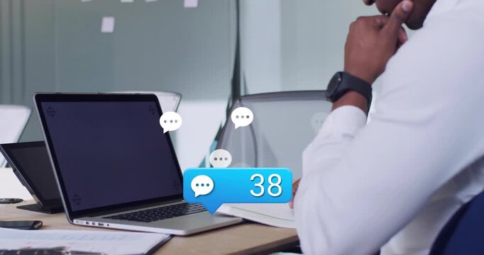 Man watching laptop as new chats arriving, badge rising and bubbles rising, showing office backlog