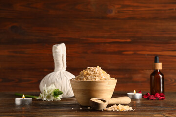 Fototapeta premium Beautiful spa composition with bowl and spoon of sea salt on brown wooden background, closeup