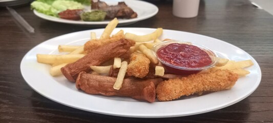 fried potatoes and sausages with tomato sauce