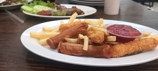 fried potatoes and sausages with tomato sauce