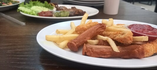 fried potatoes and sausages with tomato sauce
