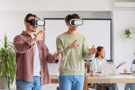 Young men using VR glasses in office