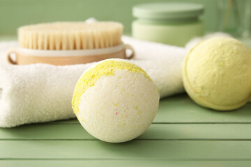 Composition with towel and bath bombs on green wooden background, closeup