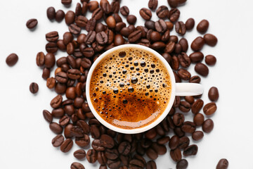 Coffee beans and cup of coffee on white background