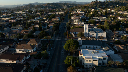 Obraz premium The sun sets on homes and a church in the historic Lincoln Heights neighborhood of Los Angeles, California, USA.