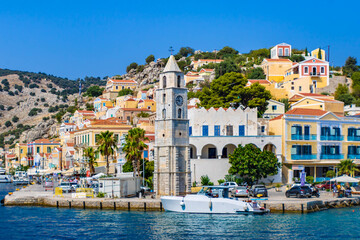 Symi town on Symi island with colorful neoclassical houses and a church, Greece