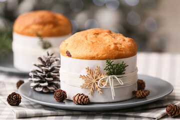 Christmas Panettone with cones and fir tree branch on table against blurred background