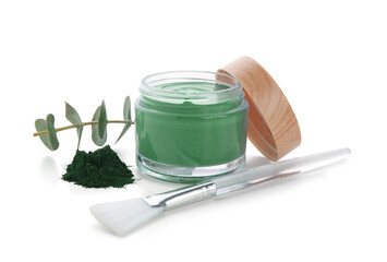 Jar of spirulina facial mask with powder, brush and eucalyptus branch on white background